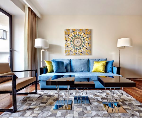 Практичный светло-синий диван в интерьере гостиной